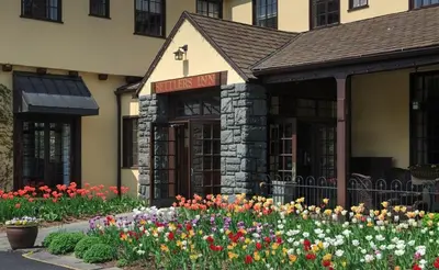 a building with a bunch of flowers in front of it at Settlers Inn in Hawley