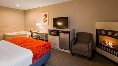 a hotel room with a bed and a fireplace at Best Western Plus New Cumberland in New Cumberland