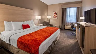 a hotel room with a bed and a flat screen tv at Best Western Plus New Cumberland in New Cumberland