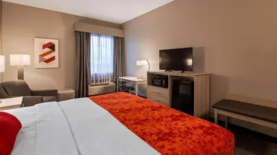 a hotel room with a bed and a flat screen tv at Best Western Plus New Cumberland in New Cumberland