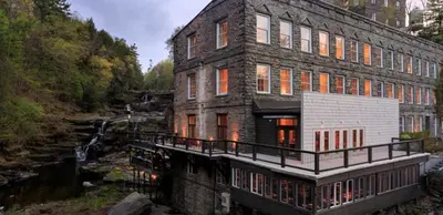 a large brick building next to a river at Ledges Hotel in Hawley