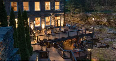a house with a deck with tables and chairs at Ledges Hotel in Hawley