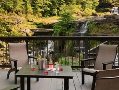 a table and chairs on a deck with a waterfall at Ledges Hotel in Hawley
