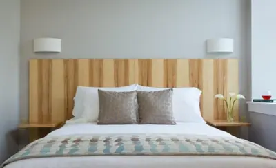 a bed with a wooden headboard in a bedroom at Ledges Hotel in Hawley