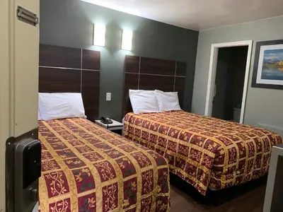 a hotel room with two beds next to each other at Red Carpet Inn - Norristown in Norristown