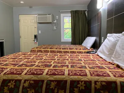 a hotel room with two beds and a window at Red Carpet Inn - Norristown in Norristown