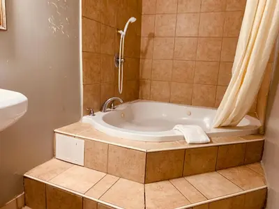a bathroom with a tub with a shower and a sink at Red Carpet Inn - Norristown in Norristown