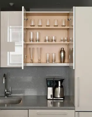 a kitchen counter with a coffee maker and glasses on shelves at ROOST East Market in Philadelphia