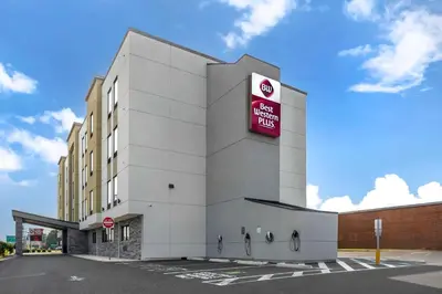a large white building with a red sign on it at Best Western Plus Philadelphia-Pennsauken Hotel in Cherry Hill