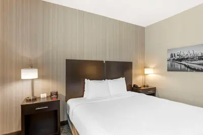 a hotel room with a large bed and two lamps at Best Western Plus Philadelphia-Pennsauken Hotel in Cherry Hill