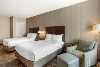 a hotel room with two beds and a chair at Best Western Plus Philadelphia-Pennsauken Hotel in Cherry Hill
