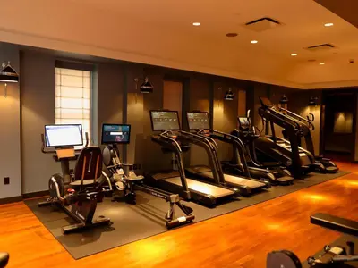 a gym with several treadmills and elliptical machines at The Ned NoMad in New York