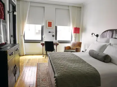a hotel room with a large bed and windows at The Ned NoMad in New York