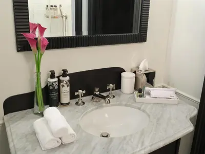 a bathroom sink with a vase with a flower on it at The Ned NoMad in New York