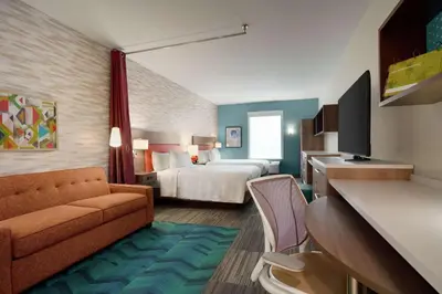 a hotel room with a bed and a couch at Home2 Suites By Hilton Warminster Horsham in Warminster
