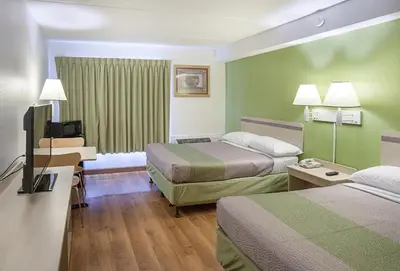 a hotel room with two beds and a flat screen tv at Motel 6-Binghamton, NY in Binghamton