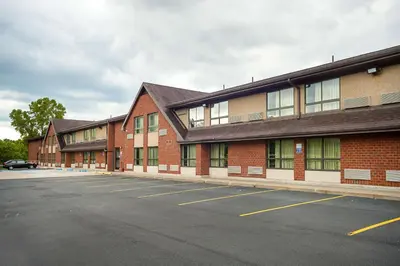 an empty parking lot in front of a brick building at Motel 6-Binghamton, NY in Binghamton