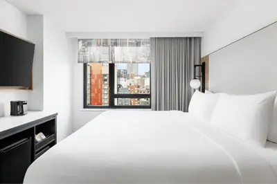 a white bedroom with a large bed and a window at Fairfield Inn & Suites by Marriott New York Manhattan/Times Square South in New York