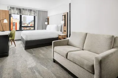 a hotel room with a couch and a bed at Fairfield Inn & Suites by Marriott New York Manhattan/Times Square South in New York