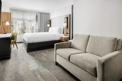 a hotel room with a bed and a couch at Fairfield Inn & Suites by Marriott New York Manhattan/Times Square South in New York