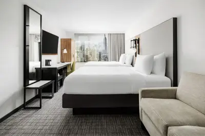 a hotel room with a large bed and a couch at Fairfield Inn & Suites by Marriott New York Manhattan/Times Square South in New York