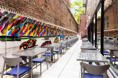 a row of tables and chairs in front of a brick wall at Fairfield Inn & Suites by Marriott New York Manhattan/Times Square South in New York