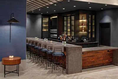 a bar in a restaurant with a row of stools at SpringHill Suites by Marriott New York Manhattan/Times Square South in New York