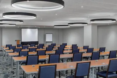 a conference room with tables and chairs and a screen at SpringHill Suites by Marriott New York Manhattan/Times Square South in New York