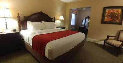 a hotel room with a large bed and a chair at The Inn at Jim Thorpe in Jim Thorpe
