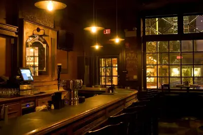 a bar in a pub with a counter and chairs at The Inn at Jim Thorpe in Jim Thorpe
