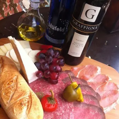 a plate of food with meat cheese grapes and wine at The Inn at Jim Thorpe in Jim Thorpe