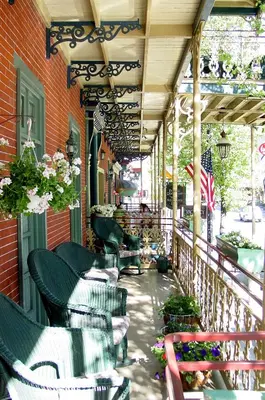an outdoor patio with chairs and flowers on a building at The Inn at Jim Thorpe in Jim Thorpe