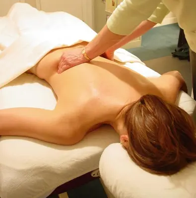 a woman getting a back massage on a bed at The Inn at Jim Thorpe in Jim Thorpe