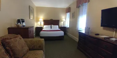 a hotel room with a bed and a television at The Inn at Jim Thorpe in Jim Thorpe