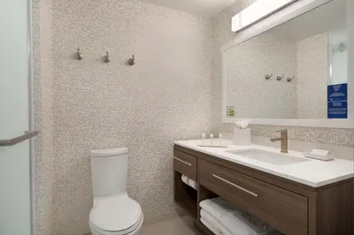 a bathroom with a toilet and a sink and a mirror at Home2 Suites By Hilton Newark Airport in Newark