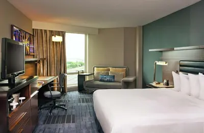 a hotel room with a bed and a desk and a television at Hilton Newark Airport in Elizabeth