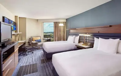 a hotel room with two beds and a flat screen tv at Hilton Newark Airport in Elizabeth