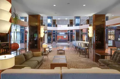 a lobby with couches and tables in a building at Hilton Newark Airport in Elizabeth