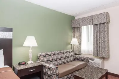 a living room with a couch in a hotel room at Howard Johnson by Wyndham Newark Airport in Newark
