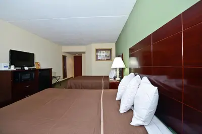 a hotel room with a large bed with white pillows at Howard Johnson by Wyndham Newark Airport in Newark