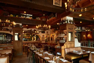 a restaurant with tables and chairs and a bar at The Bowery Hotel in New York