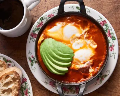 a pot of food on a plate with a cup of coffee at The Bowery Hotel in New York