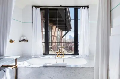 a bath tub in a bathroom with a window at The Bowery Hotel in New York