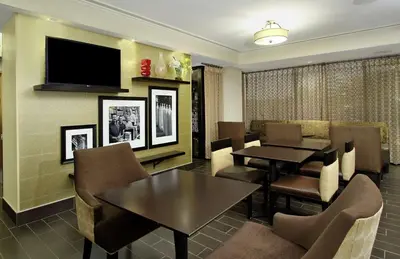 a dining room with tables and chairs and a flat screen tv at Hampton Inn Philadelphia-Great Valley in Frazer
