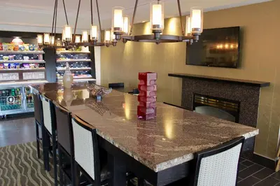 a kitchen with a bar with chairs and a fireplace at Hampton Inn Philadelphia-Great Valley in Frazer