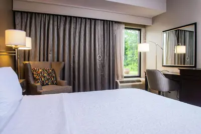 a hotel room with a bed and a desk and a window at Hampton Inn Philadelphia-Great Valley in Frazer