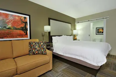 a hotel room with a bed and a couch at Hampton Inn Philadelphia-Great Valley in Frazer