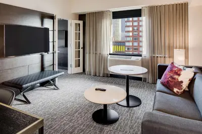 a hotel room with a couch and a tv at DoubleTree by Hilton Hotel & Suites Jersey City in Jersey City