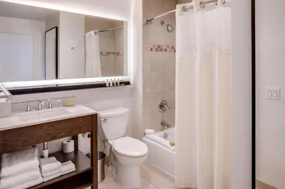 a bathroom with a toilet and a sink and a shower at DoubleTree by Hilton Hotel & Suites Jersey City in Jersey City