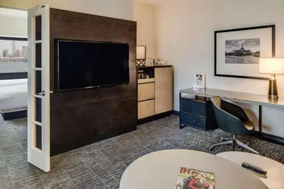 a hotel room with a flat screen tv and a desk at DoubleTree by Hilton Hotel & Suites Jersey City in Jersey City